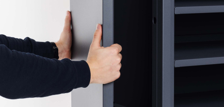 Two hands holding a dark gray panel.