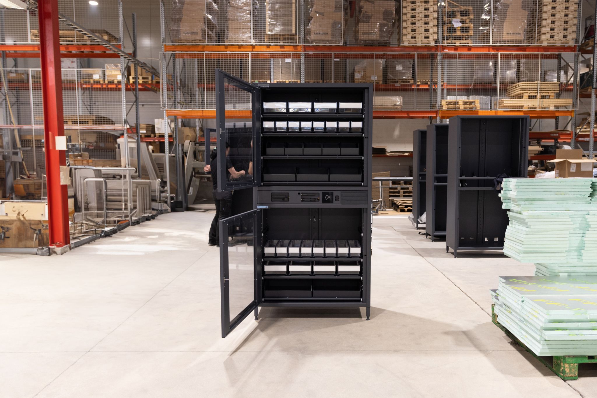 Industrial vending machine with open doors in a warehouse setting.