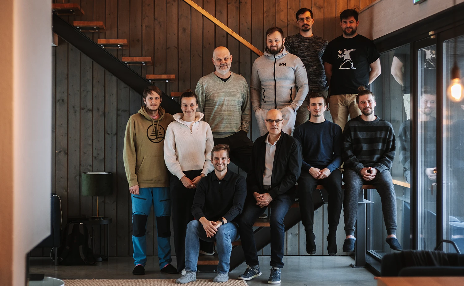 Team members of Invendor sitting on indoor steps, posing casually for a group photo.